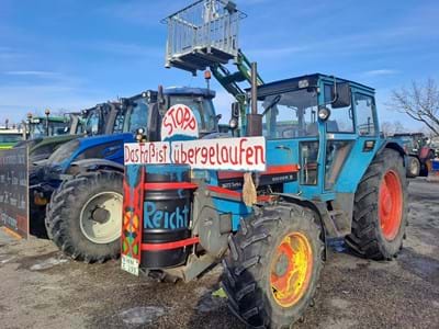 Bauernproteste Blauer Traktor mit Aufschrift Das Faß ist übergelaufen